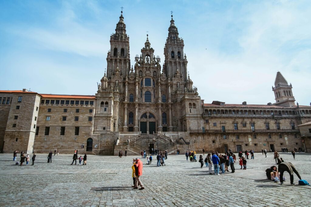 Stunning view of Santiago de Compostela Cathedral with people enjoying the sunlit plaza.