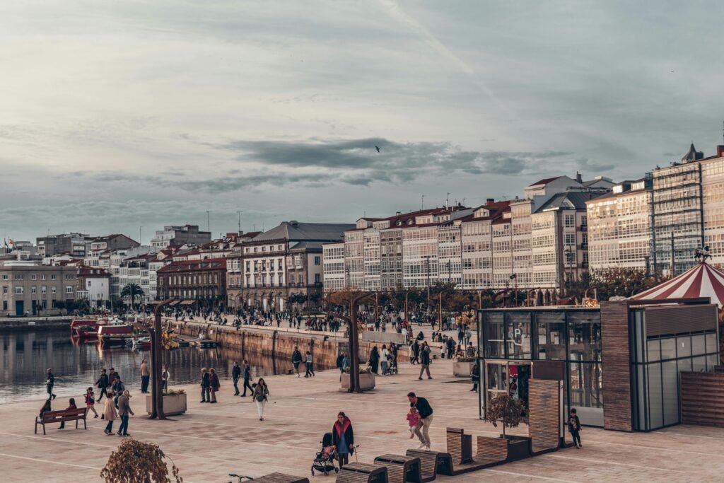 A bustling European promenade with colonial-style buildings and people enjoying a scenic waterfront.
