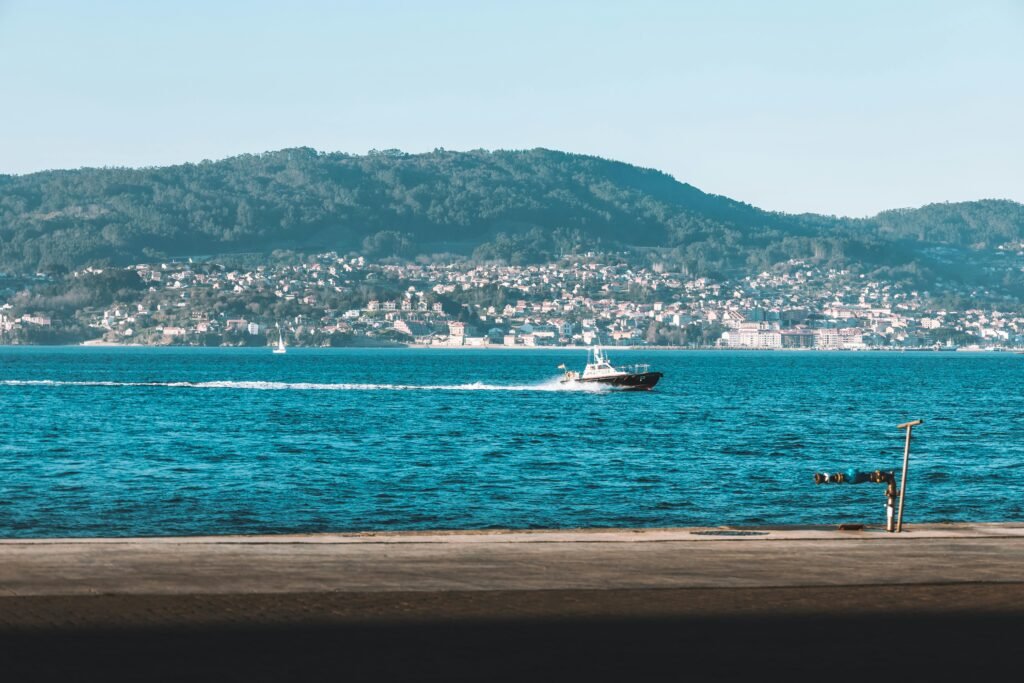 A picturesque view of Vigo, Spain, featuring a boat on the ocean.