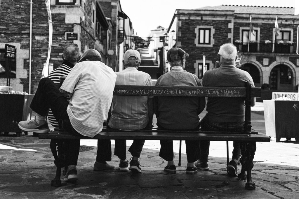 Five elderly men enjoy a calm moment on a bench in Santiago's historic center.