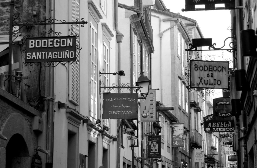 Black and white photo of signs on a historic street in Santiago de Compostela, Spain