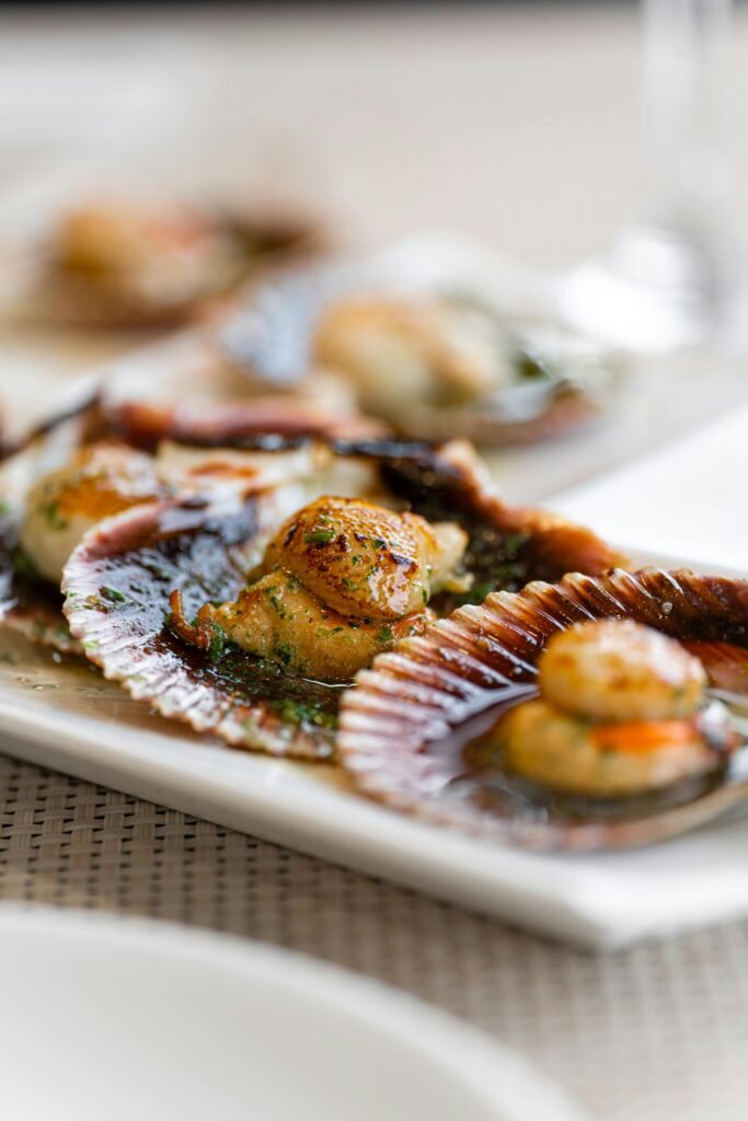 Deliciously cooked scallops artistically presented on shells for a gourmet meal setting.