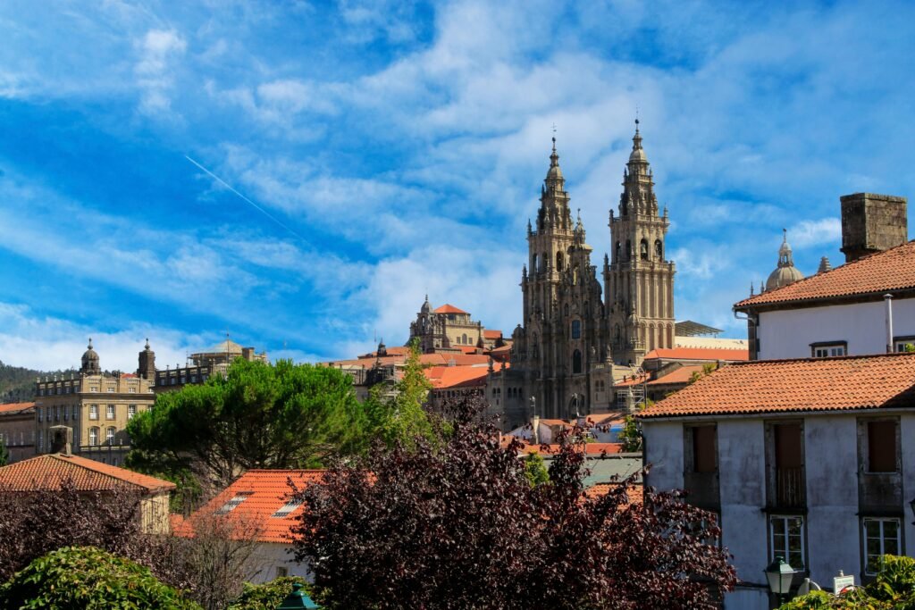 A scenic view of Santiago de Compostela with the iconic cathedral under a vibrant blue sky.